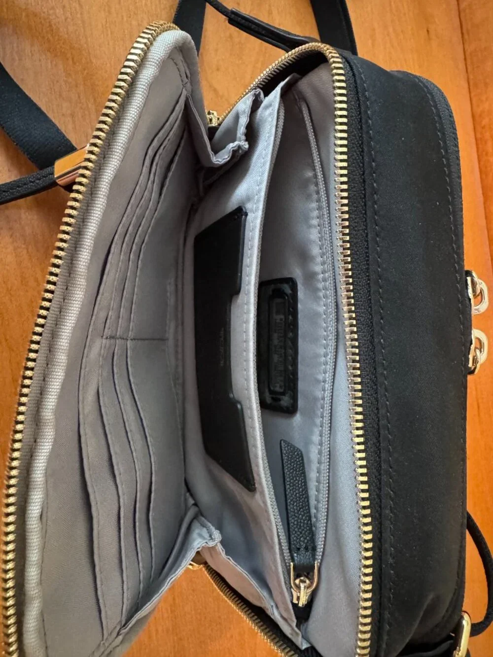 Authentic TUMI Voyageur Langley Crossbody in black with gold-tone hardware